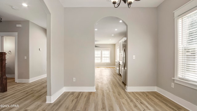 hall featuring a notable chandelier and light wood-type flooring