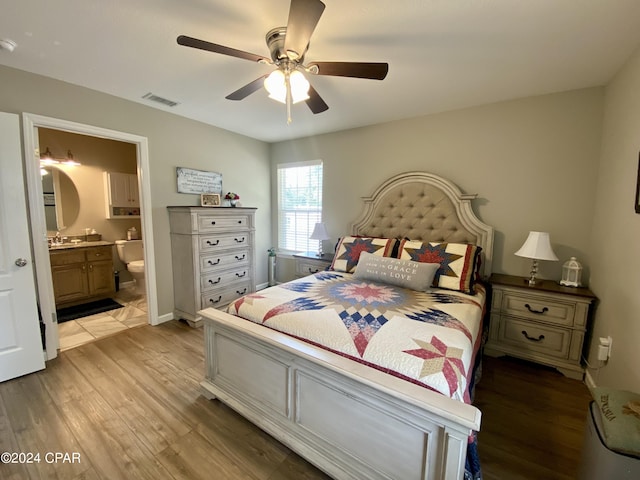 bedroom featuring ceiling fan, connected bathroom, and light hardwood / wood-style flooring