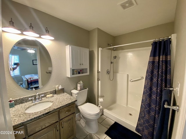 bathroom with tile patterned floors, walk in shower, vanity, ceiling fan, and toilet