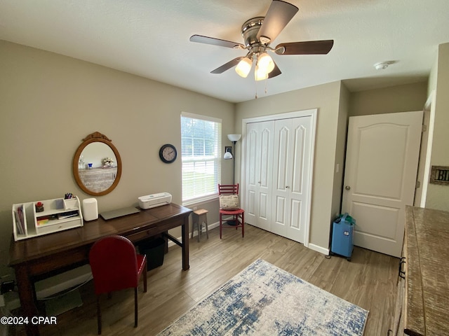 office space with light wood-type flooring and ceiling fan