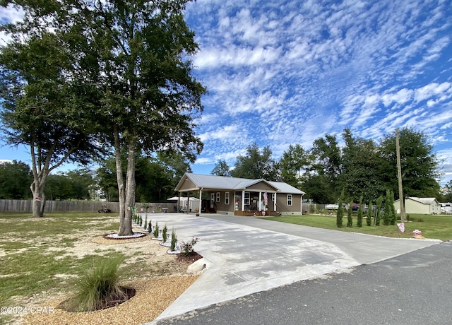 view of front facade with a carport, covered porch, and a front yard