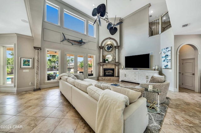 living room featuring french doors, a high ceiling, and crown molding