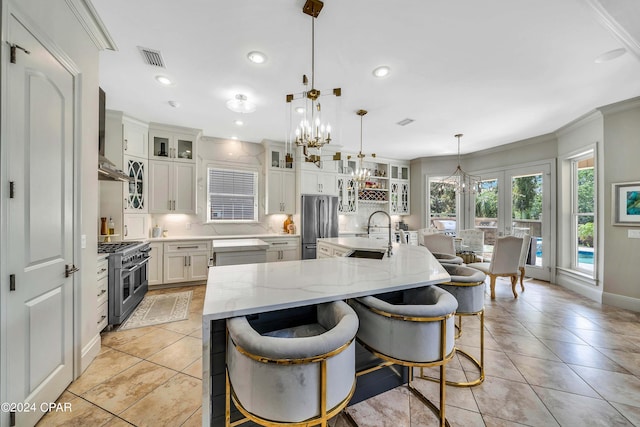 kitchen featuring decorative backsplash, decorative light fixtures, an inviting chandelier, stainless steel appliances, and a large island with sink