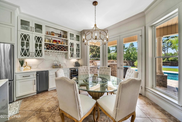 dining space featuring a notable chandelier, light tile patterned floors, ornamental molding, and beverage cooler