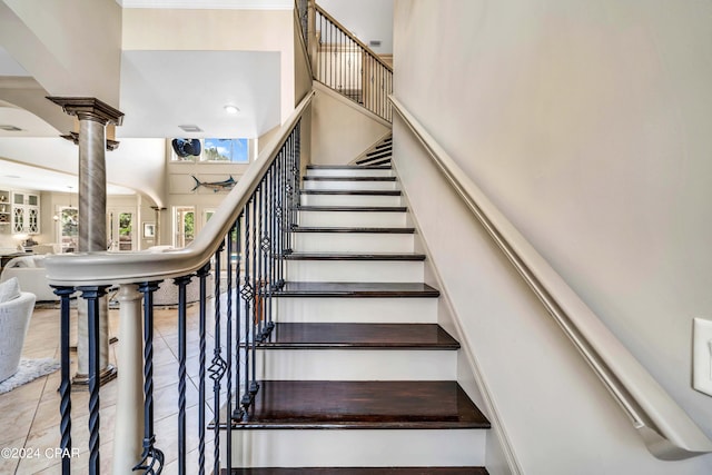 stairway featuring ornate columns and tile patterned flooring