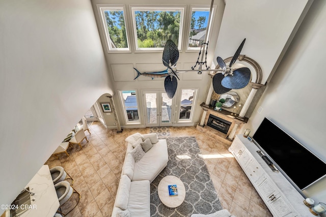 living room featuring a high ceiling, tile patterned floors, and plenty of natural light