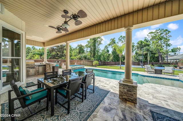 view of patio / terrace with a fenced in pool, exterior kitchen, grilling area, and ceiling fan