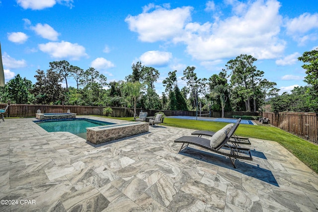 view of pool with an in ground hot tub, a patio area, and a yard