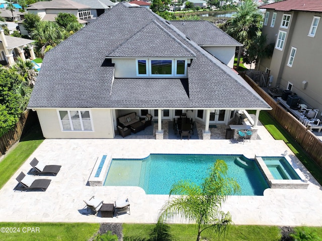 rear view of house with a swimming pool with hot tub, outdoor lounge area, and a patio