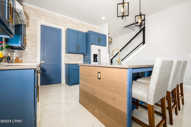 kitchen featuring blue cabinets, hanging light fixtures, sink, high end fridge, and a kitchen breakfast bar