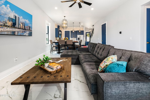 living room featuring ceiling fan with notable chandelier