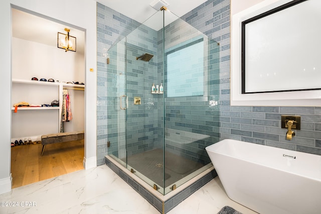 bathroom featuring shower with separate bathtub and wood-type flooring