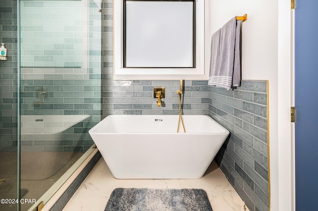 bathroom featuring tile walls, a washtub, and sink