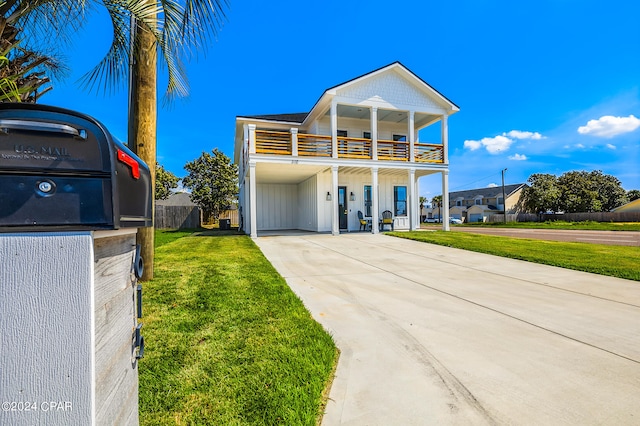 view of front facade with a balcony and a front lawn