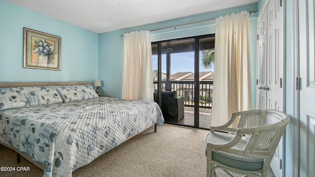 carpeted bedroom featuring access to outside, a textured ceiling, and a closet