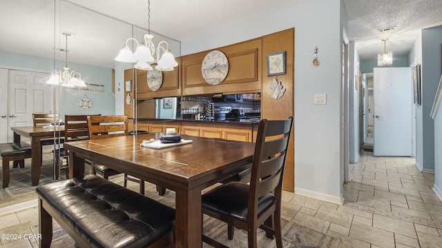 dining area featuring an inviting chandelier, stone tile flooring, visible vents, and baseboards