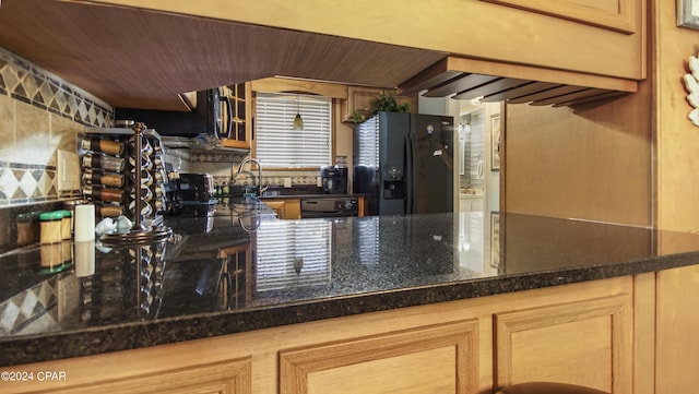 kitchen featuring tasteful backsplash, a sink, and black appliances