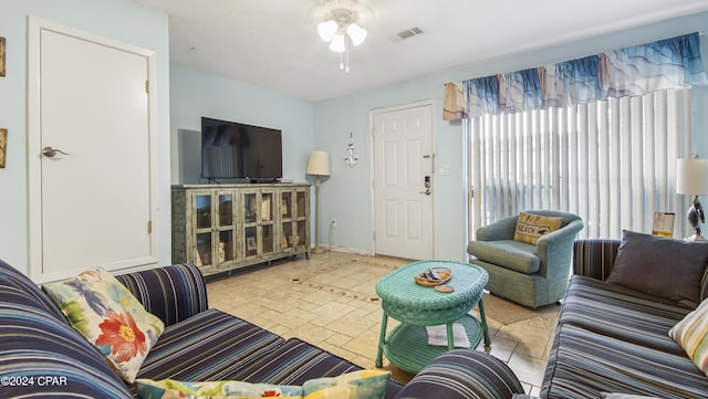 living area with a ceiling fan and visible vents