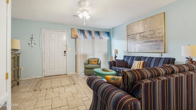 living room featuring a textured ceiling and ceiling fan