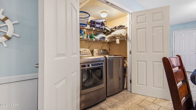 laundry room with a textured ceiling and washer and dryer