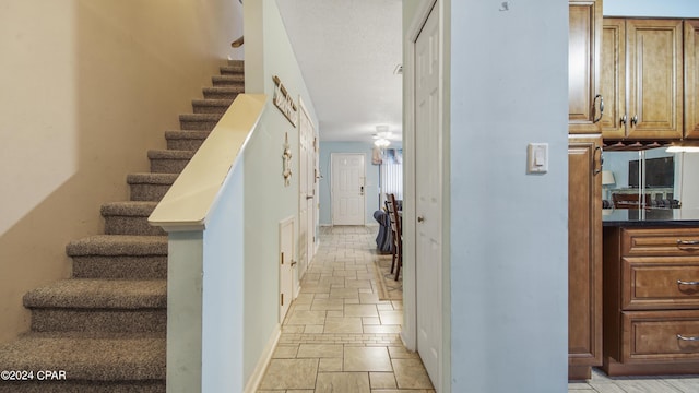 stairway with baseboards and stone tile flooring