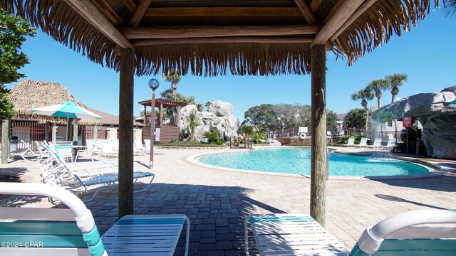 view of swimming pool with pool water feature and a patio area