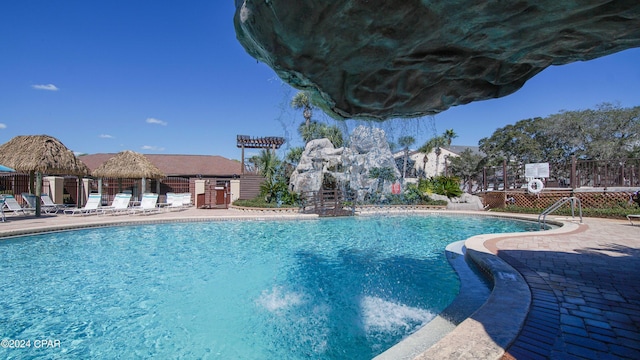 pool with a patio and fence