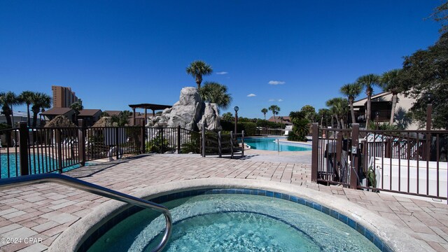 view of pool featuring a community hot tub and a patio area