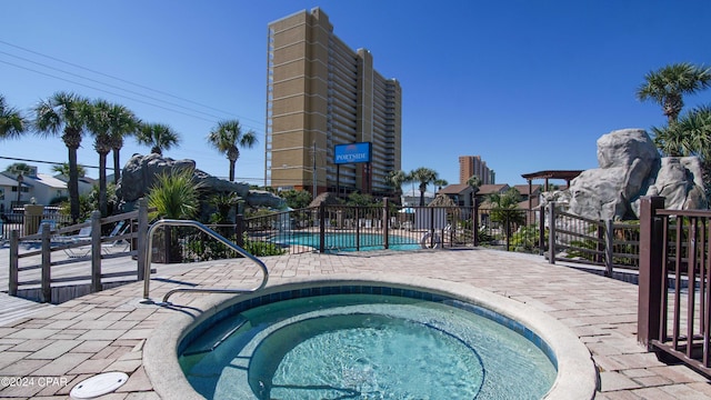 community pool with a community hot tub and fence
