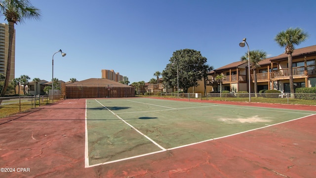 view of sport court with a residential view and fence