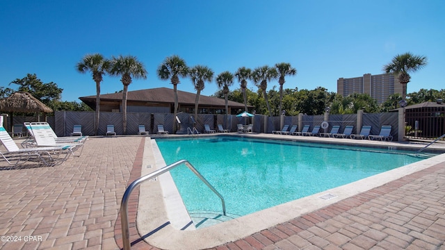 pool featuring fence and a patio area