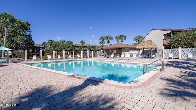pool featuring fence and a patio area