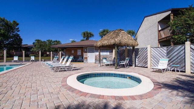 view of swimming pool featuring a hot tub, a patio, and a gazebo