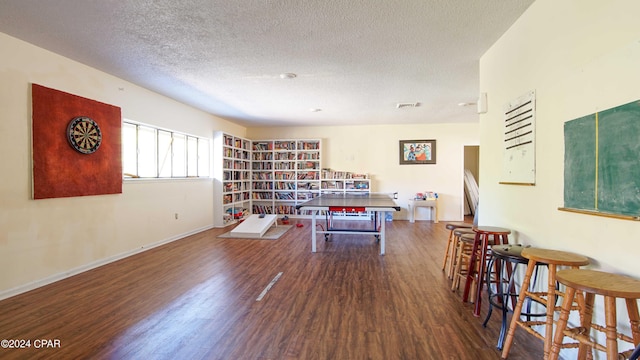 sitting room with baseboards, visible vents, wood finished floors, and a textured ceiling