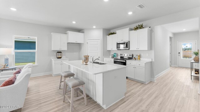 kitchen with sink, appliances with stainless steel finishes, light hardwood / wood-style floors, and gray cabinetry