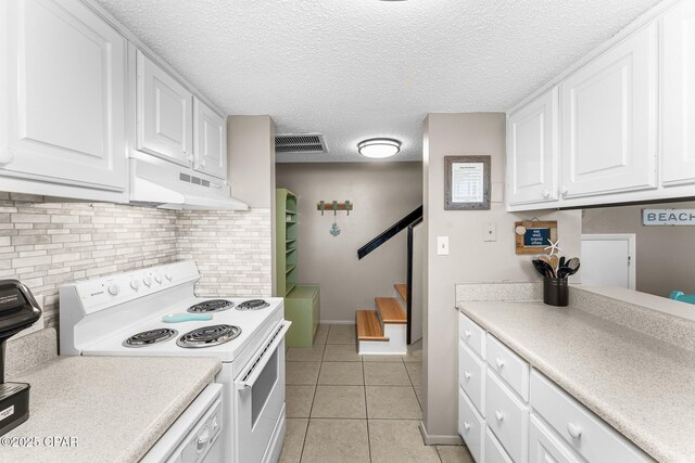 kitchen featuring white cabinetry, decorative backsplash, light tile patterned floors, white appliances, and a textured ceiling