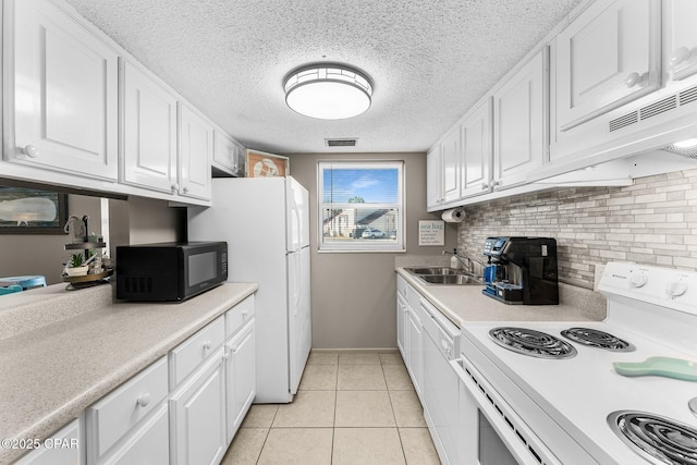 kitchen featuring sink, white appliances, light tile patterned floors, backsplash, and white cabinets