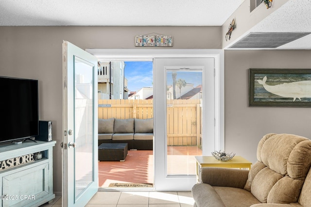 doorway to outside with light tile patterned floors and a textured ceiling