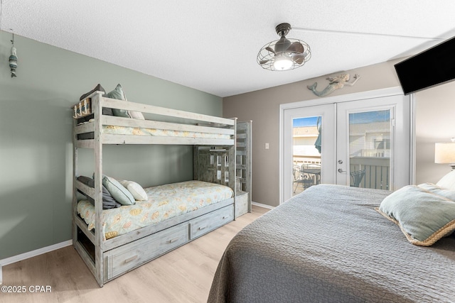 bedroom featuring french doors, access to exterior, hardwood / wood-style floors, and a textured ceiling