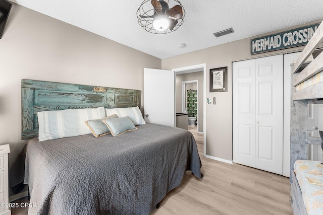 bedroom featuring a textured ceiling and light hardwood / wood-style flooring