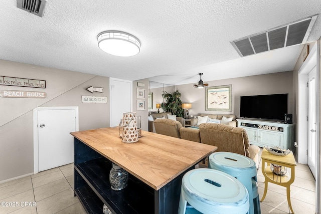 tiled dining space with a textured ceiling