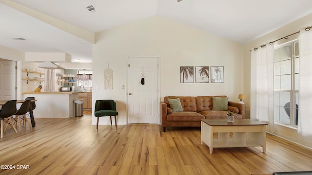 living room featuring vaulted ceiling and light hardwood / wood-style flooring