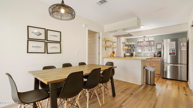 dining space featuring light wood-type flooring and sink