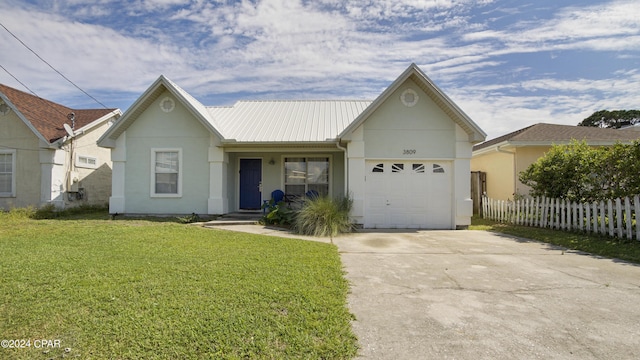 3809 Mystic St, Panama City, FL 32408 - ranch-style house with fence, a garage, driveway, a front yard, and metal roof