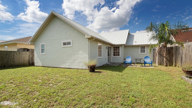 back of property with a patio and a yard