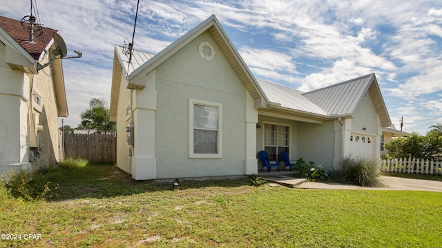 exterior space featuring a garage and a lawn