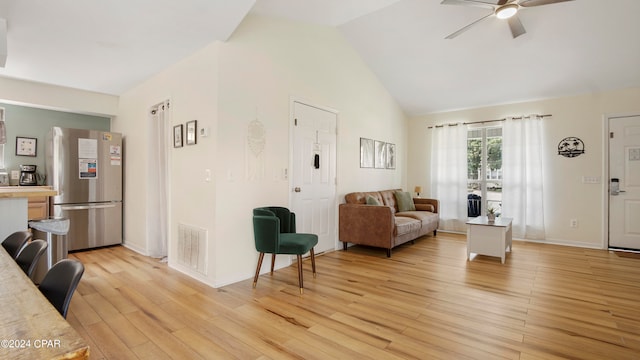 living room featuring ceiling fan, light hardwood / wood-style flooring, and high vaulted ceiling