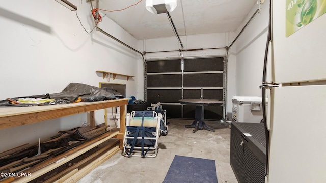 garage featuring white refrigerator and a garage door opener