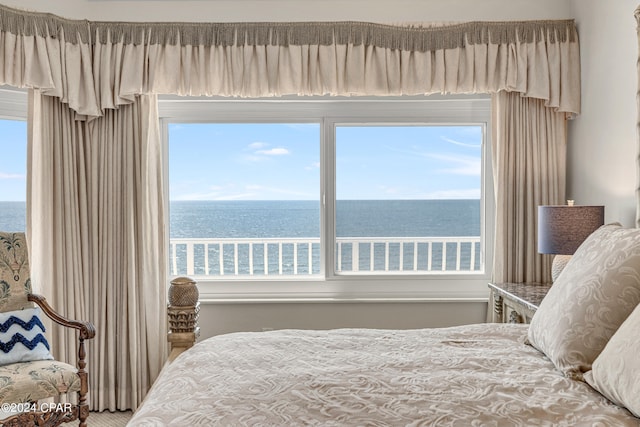 bedroom featuring multiple windows and a water view