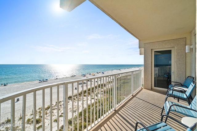 balcony featuring a water view and a beach view